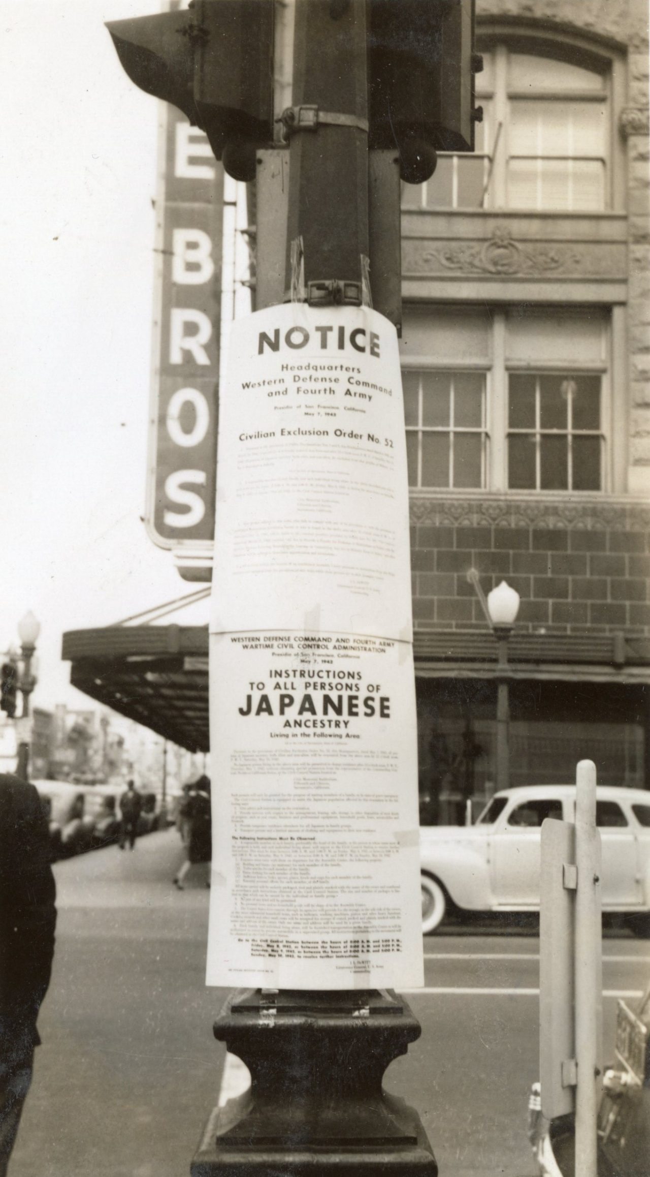 Photo of signs posted to a pole, telling Japanese Americans in the area that they are being removed