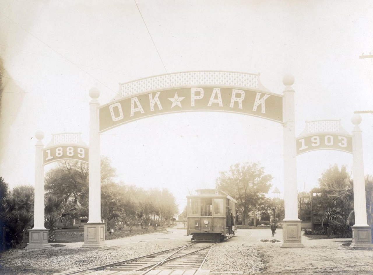 Oak Park sign with a street car moving away from the camera and underneath the sign