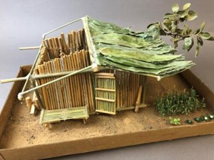 a homemade model of a Hmoob house made with bamboo