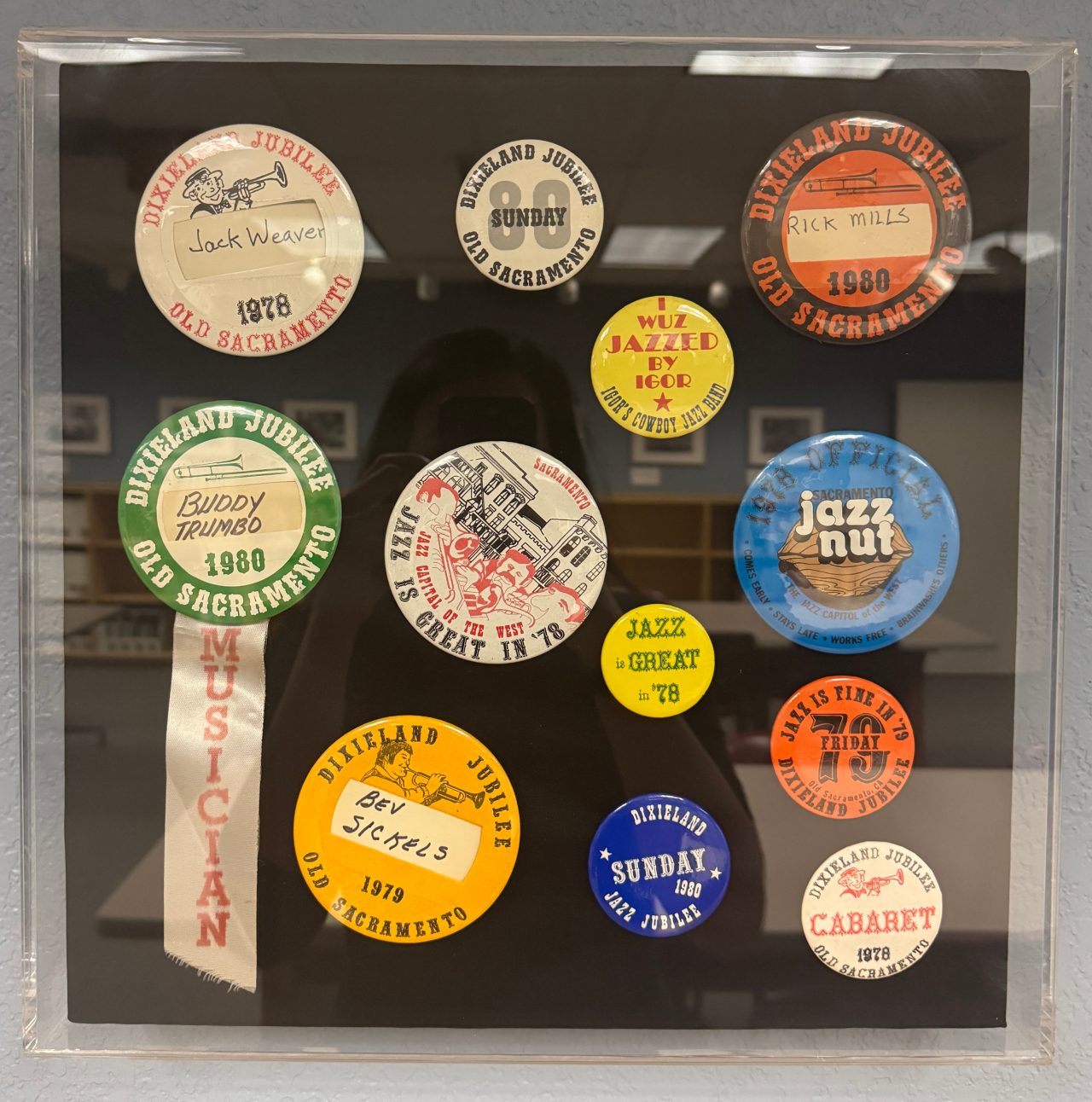A shadow box filled with various buttons from the Jazz Jubilee