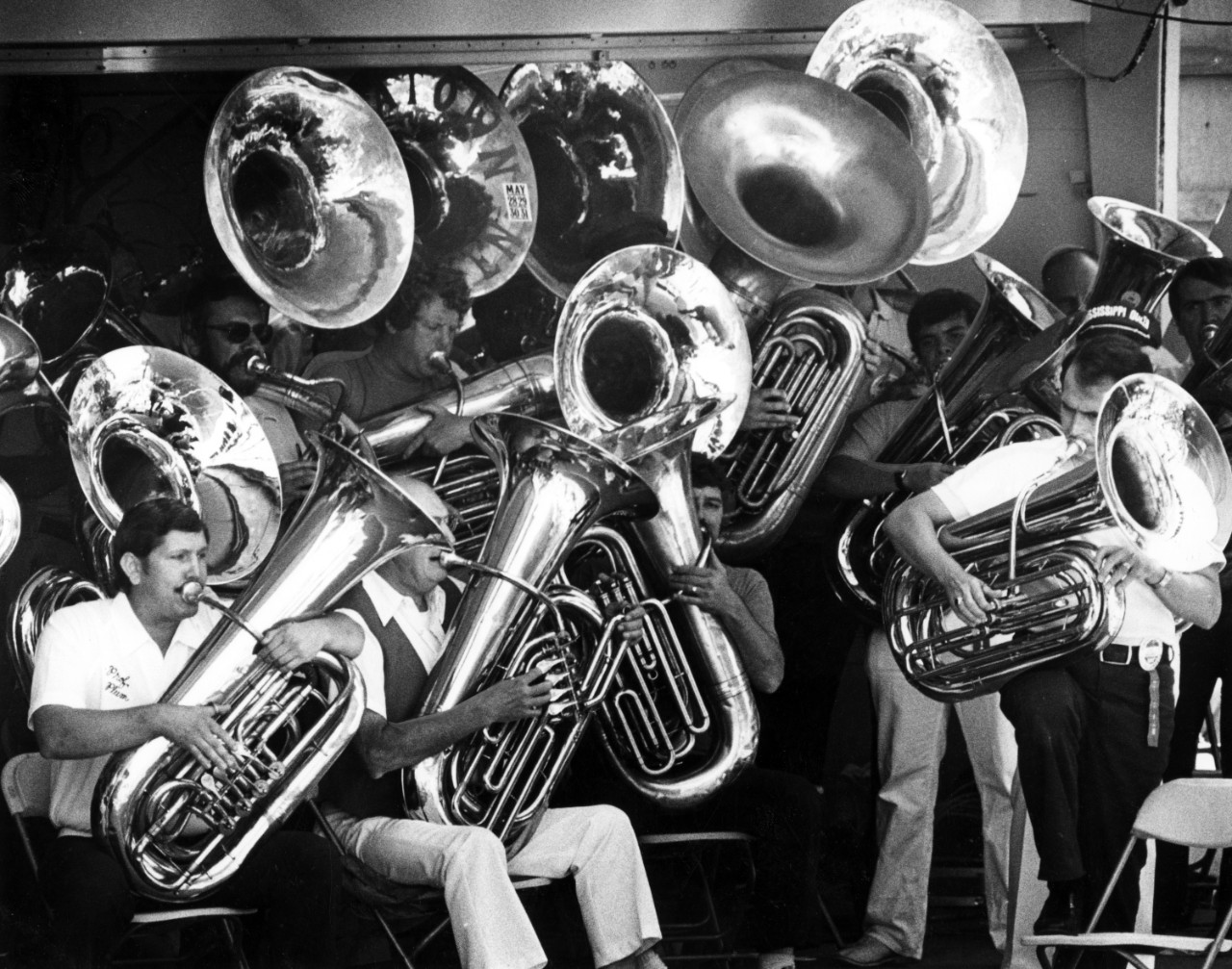 A group of tubas and their players on stage.
