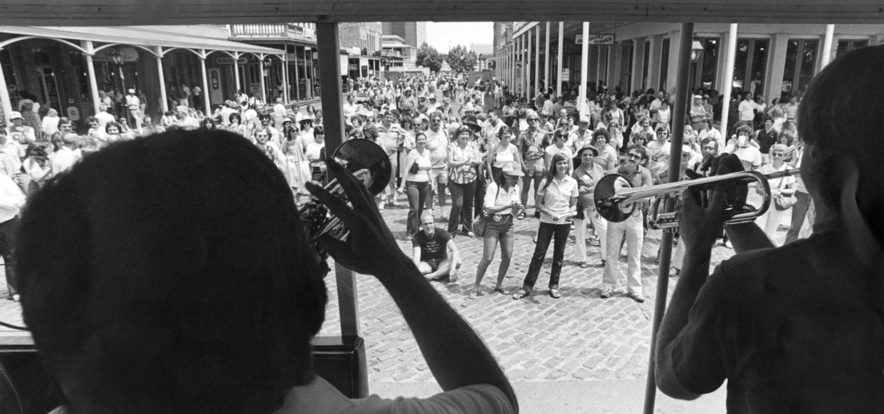 Looking through two trumpet players to a gathered crowd in Old Sacramento