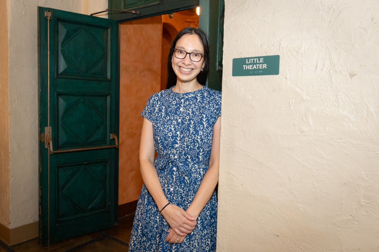 Author Beth Lew-Williams leaning against a wall in a dress.